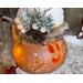 This image shows the candlelight shining through Tinsel's face and decorative snowflakes carved into the gourd shell. 
